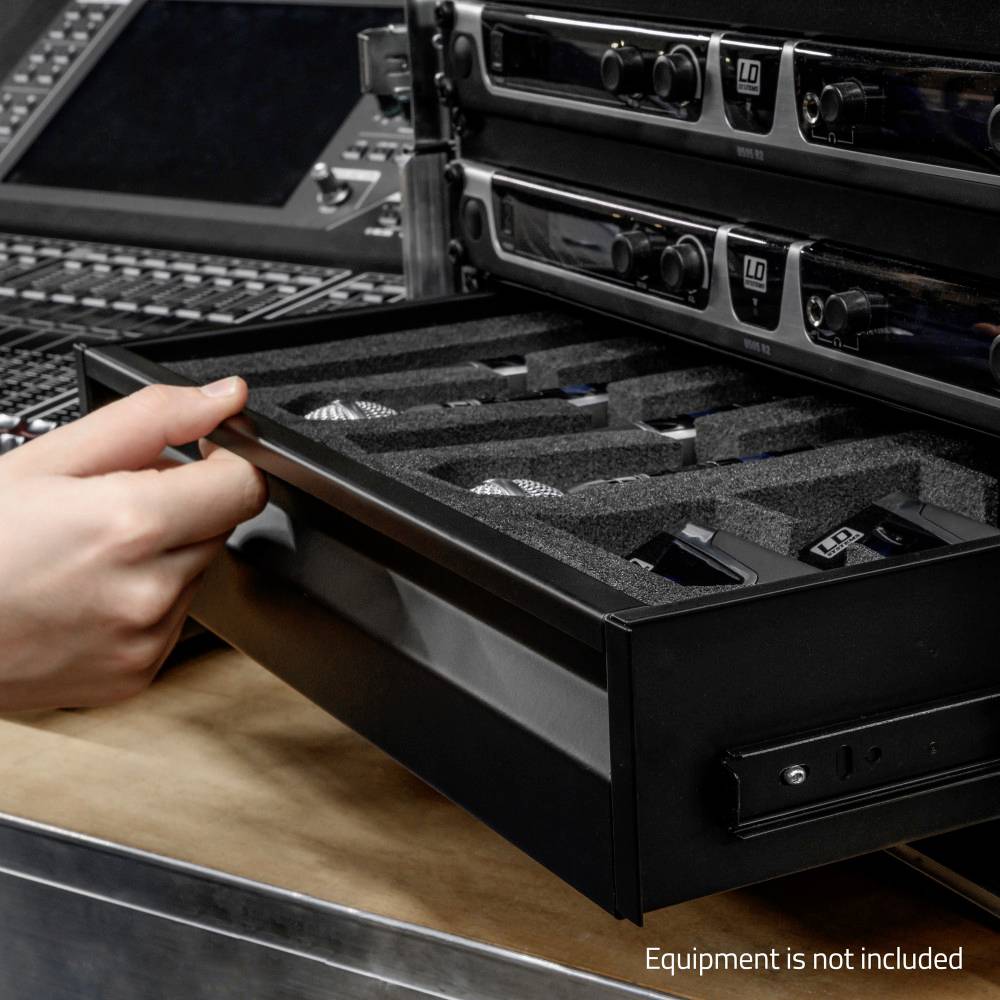 Une main tire un tiroir avec des compartiments rembourrés et des appareils électroniques d'un espace de rangement situé sous un équipement audio.