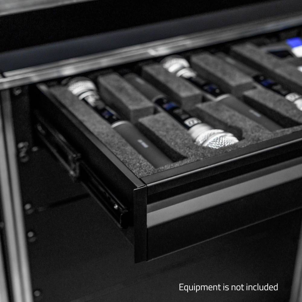 Plusieurs microphones sont rangés en toute sécurité dans un insert en mousse à l'intérieur d'un tiroir ouvert. Texte sur l'image : « L'équipement n'est pas inclus ».
