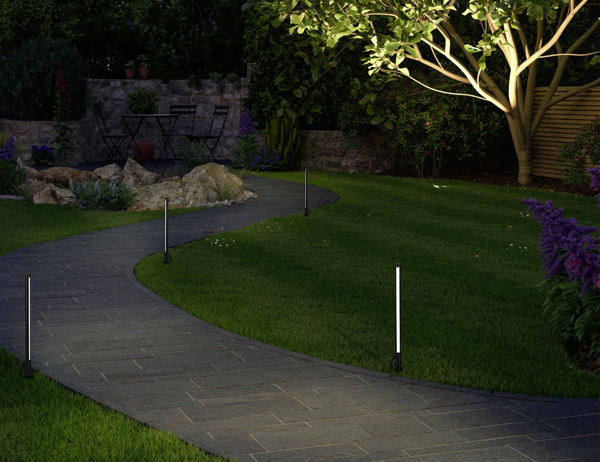 Un chemin de jardin éclairé traverse une pelouse bien entretenue, bordé de lampadaires, d'arbustes et d'un grand arbre illuminé.