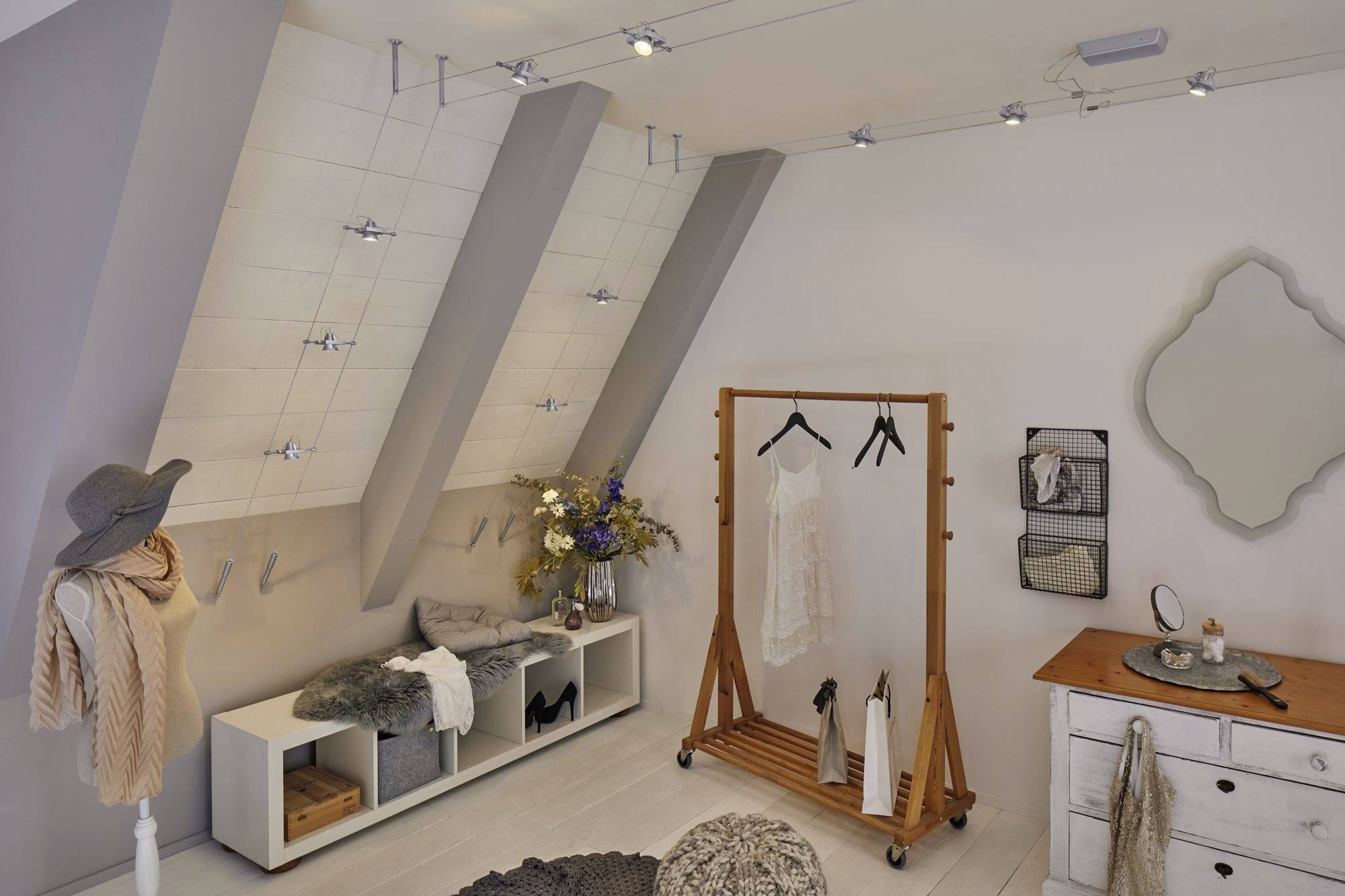 Dressing ouvert avec penderie accessible, vêtements sur portants, étagères décoratives et accessoires tels que chapeaux et écharpes.