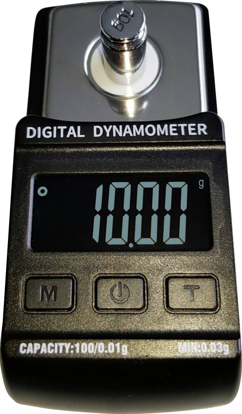 Dynamomètre numérique affichant actuellement '10,00 g'. Présente des touches pour le mode, l'unité et la mise en marche.
