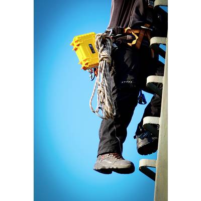 Une personne grimpe sur une échelle, portant un équipement de sécurité et tenant une valise jaune, devant un ciel bleu clair et dégagé.