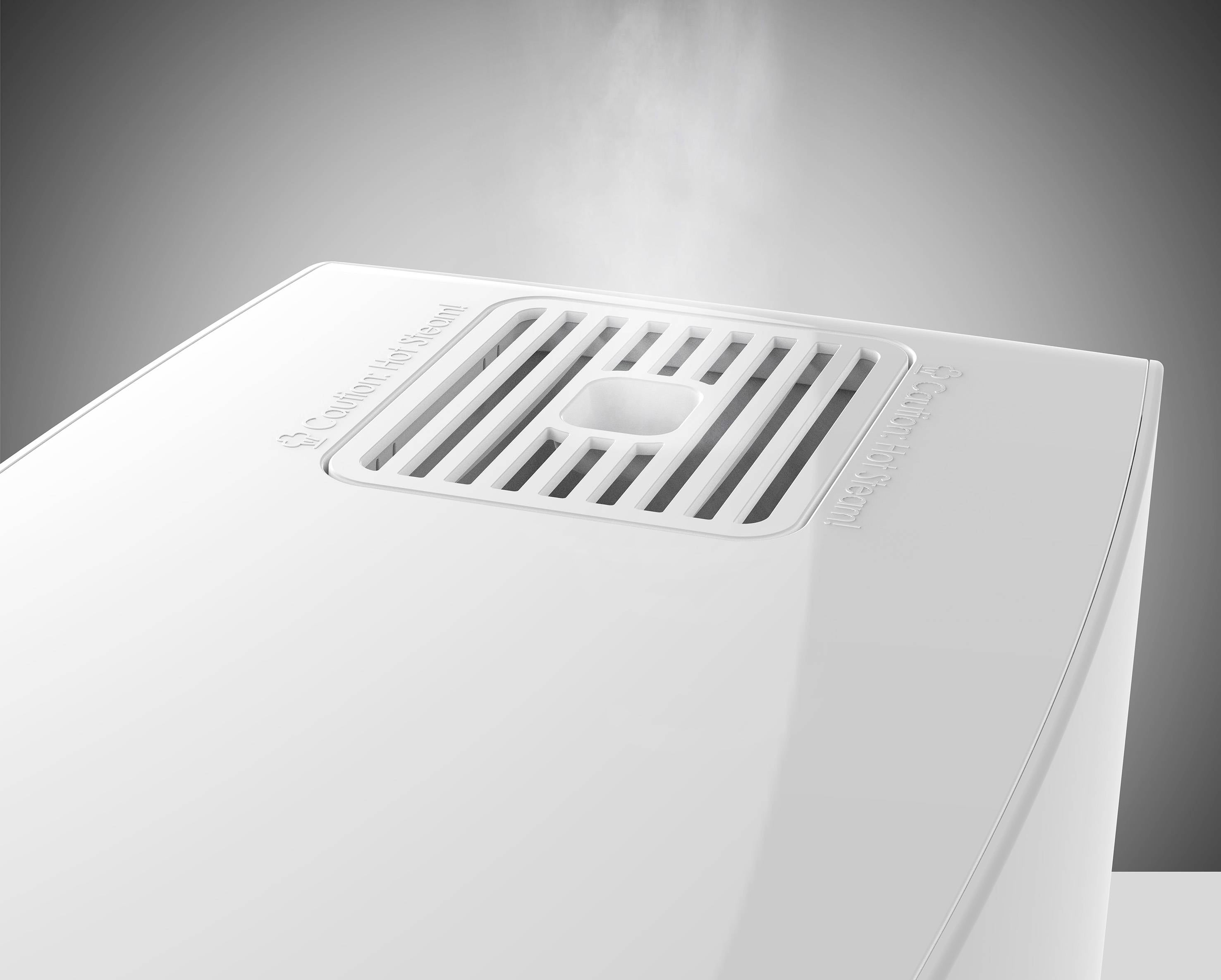 Humidificateur sur une table, de la vapeur s'élève ; le logo de la marque est visible en haut de l'appareil, indiquant son fonctionnement actif.