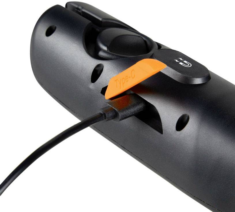 Une télécommande noire connectée à un câble de charge USB-C, une étiquette orange portant l'inscription 'Type-C' est visible.