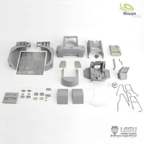 Kit de modélisme 'Thicon' pour un camion miniature. Divers composants en plastique gris soigneusement disposés. Contient des pièces pour la construction du véhicule.
