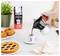 Une personne verse du café d'une cafetière Moka dans une tasse à espresso. À proximité se trouvent des croissants, une tarte et un sac de café Bialetti sur un comptoir de cuisine.