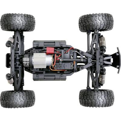 'Vue supérieure d'une voiture télécommandée sans carrosserie, montrant le moteur, les câbles, la suspension et de grandes roues profilées.'