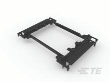 Un cadre en plastique noir, probablement une pièce de rechange ou un support de montage pour des appareils électroniques. L'arrière-plan est flou.