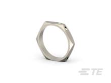 Une bague hexagonale argentée à surface lisse est posée sur le côté. Design minimaliste sur un fond neutre.