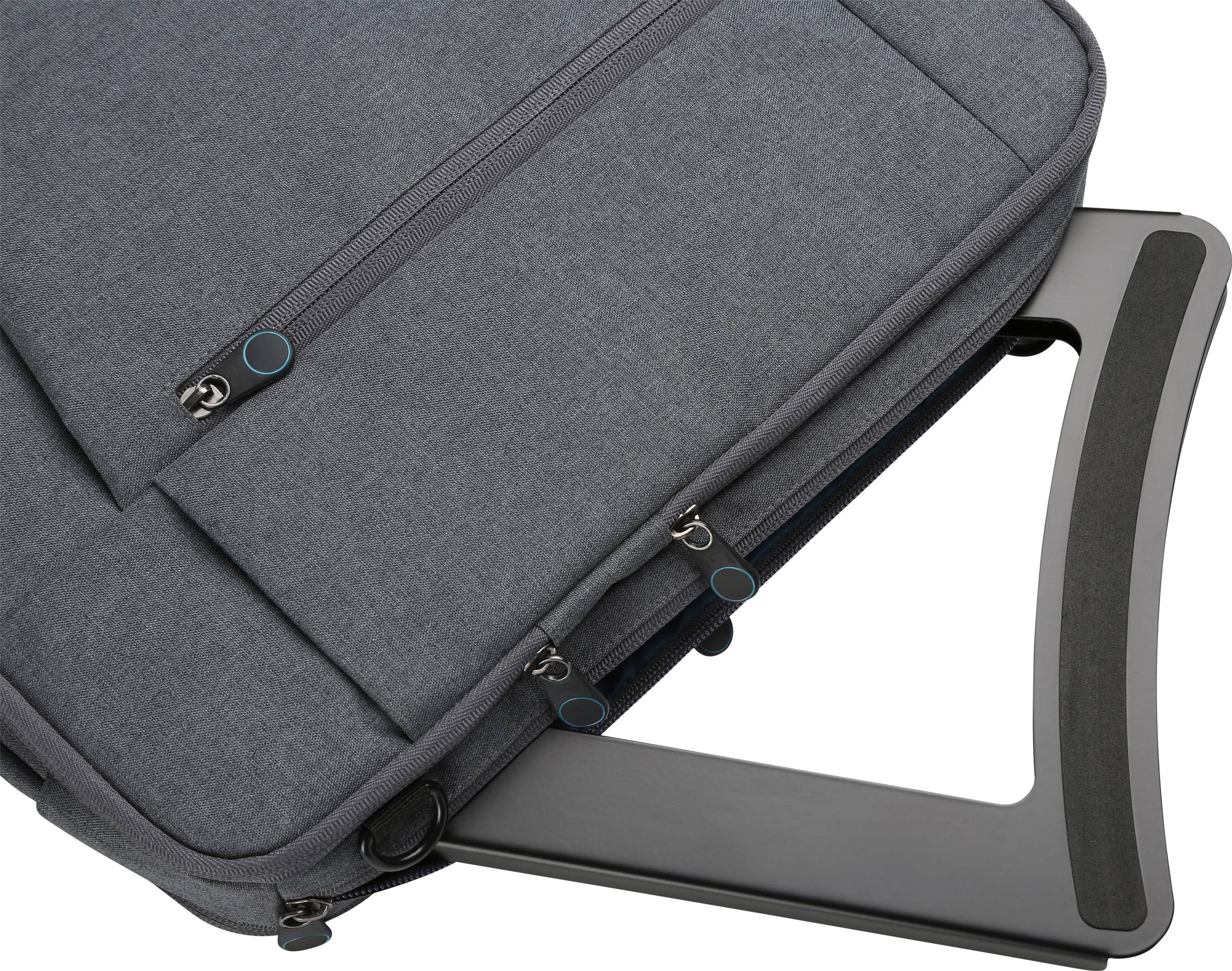 Sac à dos gris pour ordinateur portable fixé sur la poignée d'un trolley. Le sac à dos possède plusieurs poches à fermeture éclair et est solidement attaché au bagage de voyage.