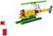 Hélicoptère Lego coloré avec des pales de rotor, une queue jaune et une minifigurine à l'intérieur. À gauche, un morceau de drapeau Lego rouge sur un socle.