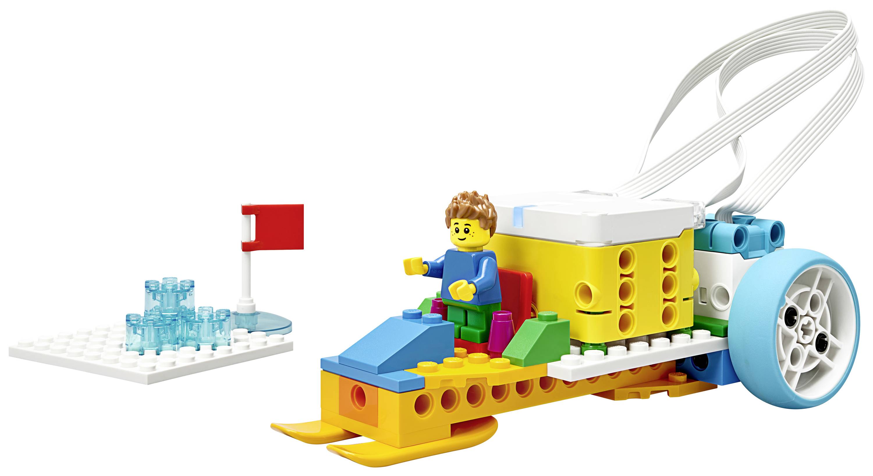 Une voiture Lego colorée avec une figurine assise et un capteur à l'avant. Un petit drapeau est placé sur une plaque de construction blanche séparée.