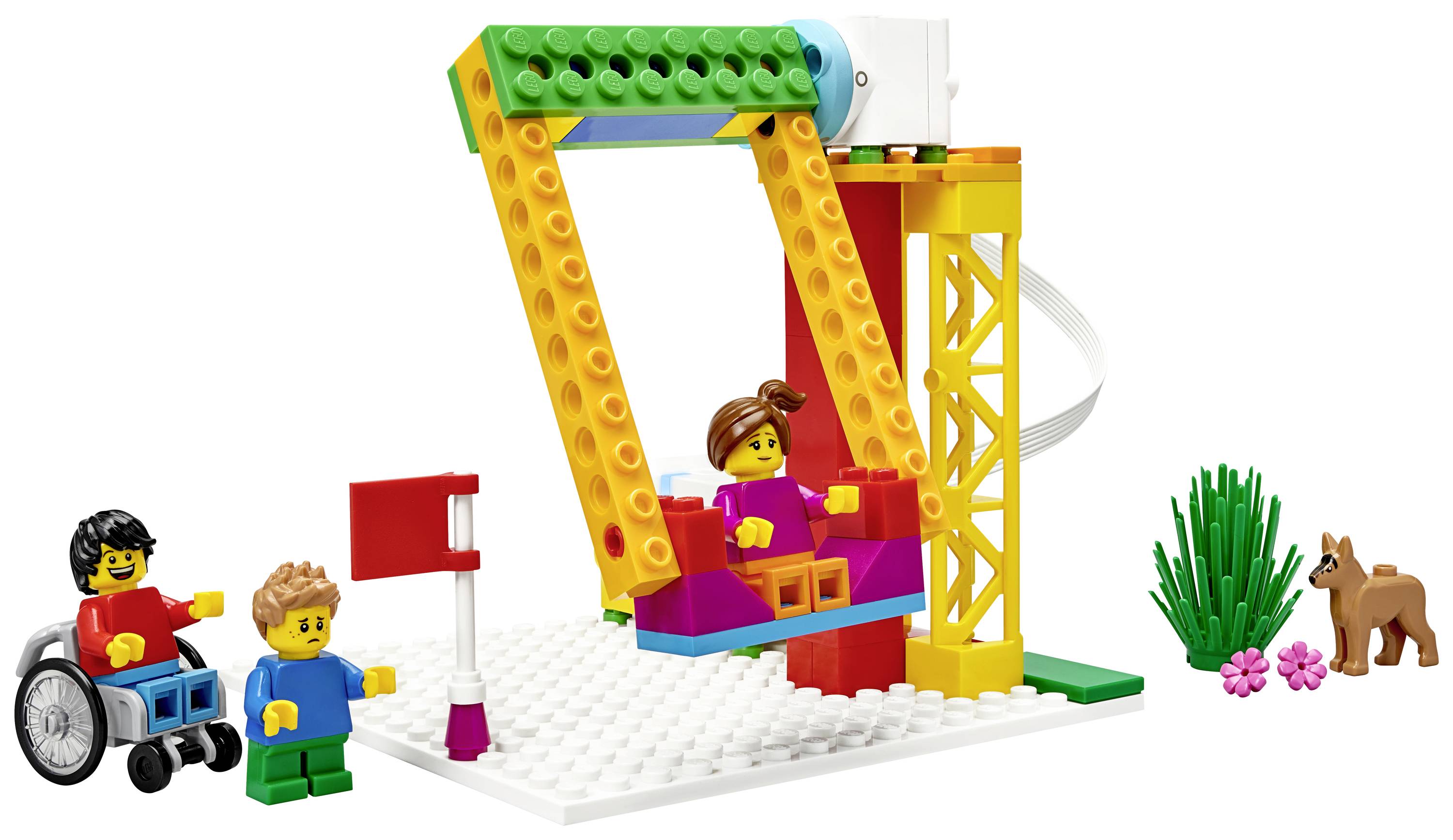 Un enfant en fauteuil roulant et un autre enfant sont à côté d'une balançoire LEGO, sur laquelle est assis un troisième enfant. Des plantes et un petit animal sont visibles en arrière-plan.