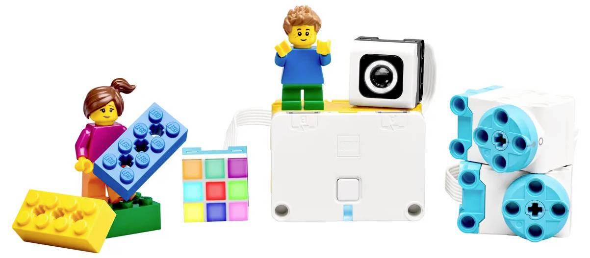Figurines de jouets et blocs de construction colorés : Une fille portant un haut rose et un garçon portant un haut bleu, entourés de blocs aux allures technologiques.