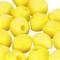 Des perles en plastique jaunes, rondes et creuses, sur un fond blanc.