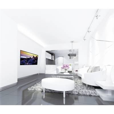 Salon blanc et moderne avec une table ovale, un tapis moelleux, un canapé et une télévision murale. La pièce paraît lumineuse et spacieuse.