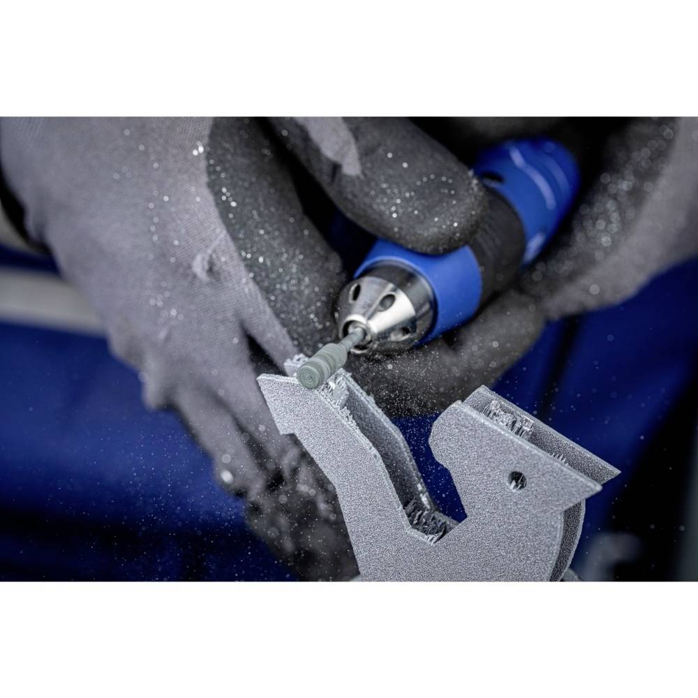 'Un ouvrier portant des gants de protection, utilise un outil de meulage sur une surface métallique, des étincelles volent autour.'