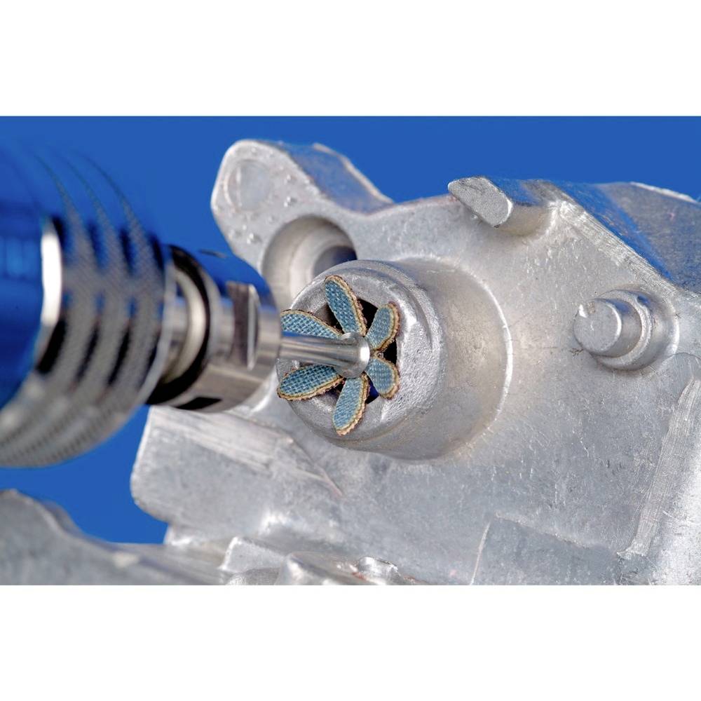 Un outil de meulage traite la surface d'une pièce métallique. L'outil tourne et crée des bords fins et brillants.