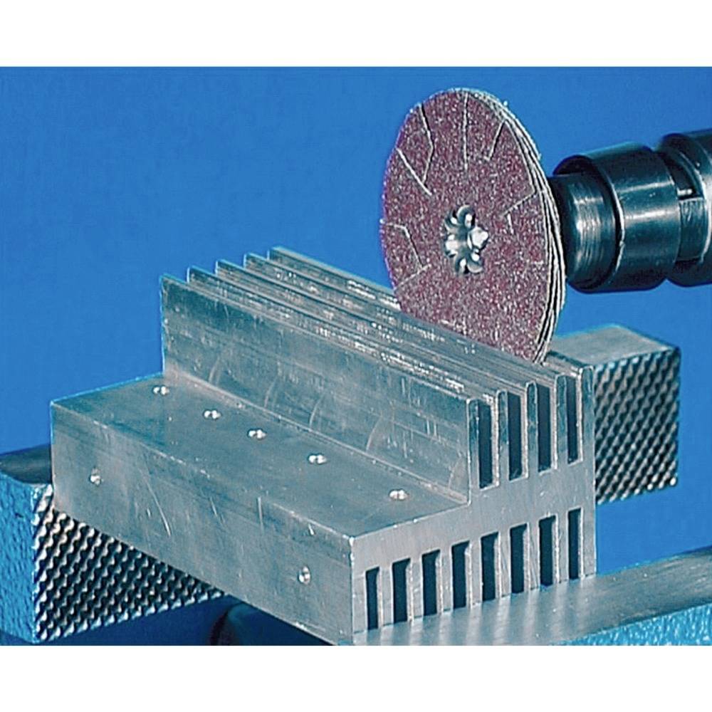 'Gros plan sur une machine de découpe métallique, le disque abrasif usinant une plaque d'aluminium avec plusieurs encoches régulières.'