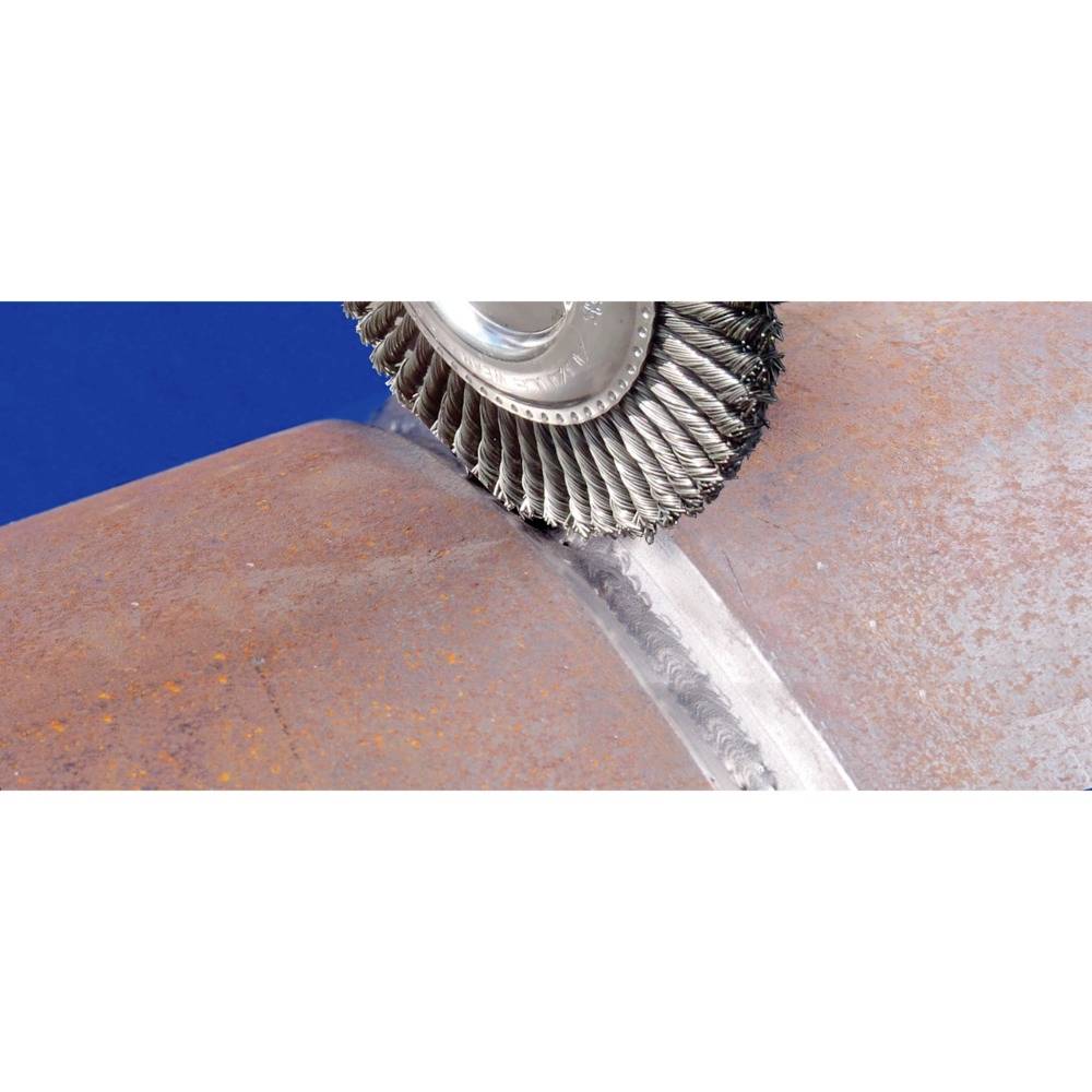 Un meuleuse d'angle équipée d'une brosse métallique retire la rouille d'un grand raccord de tuyau métallique pour nettoyer la surface.