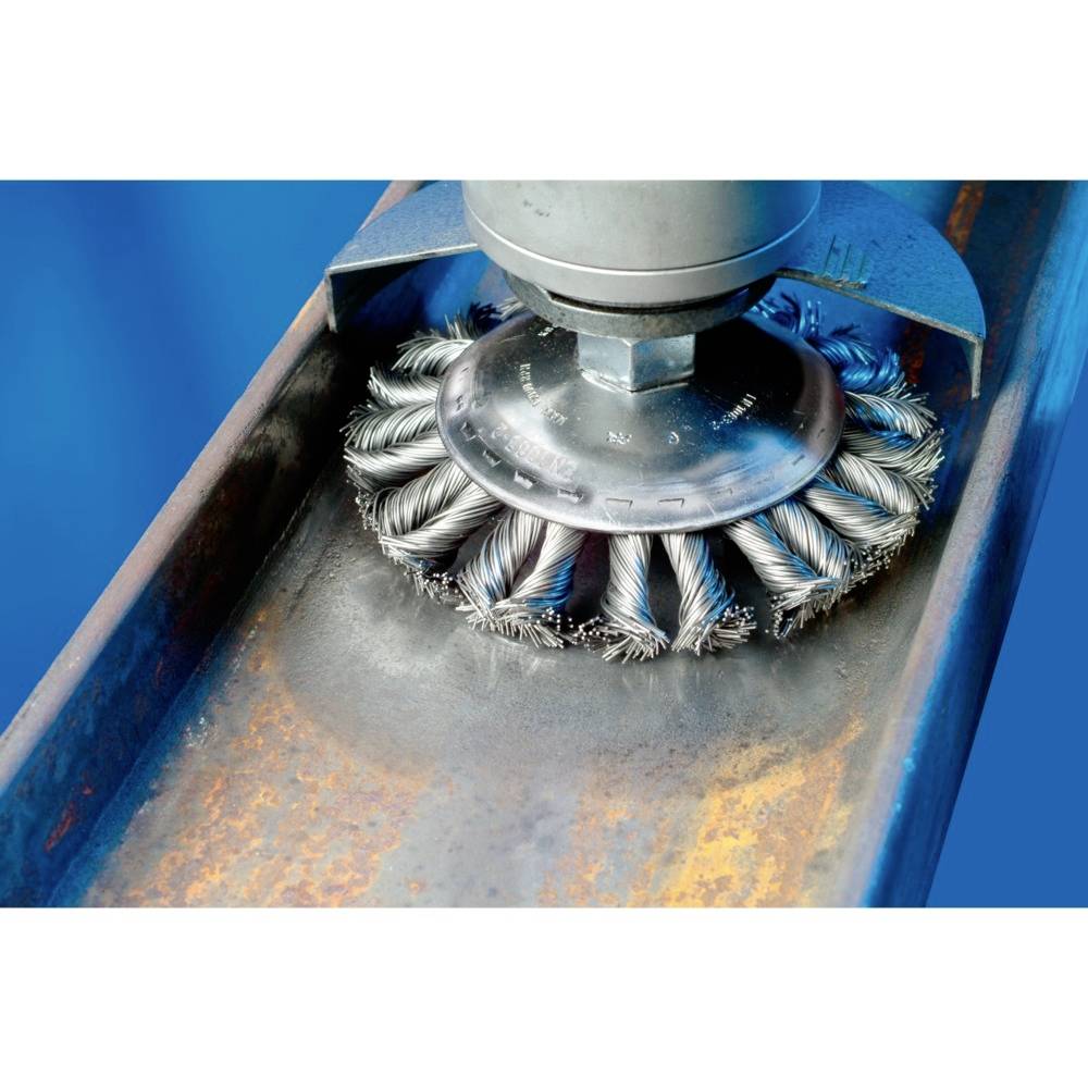 Une brosse métallique rotative traite la surface d'un support métallique, élimine la rouille et nettoie la surface.