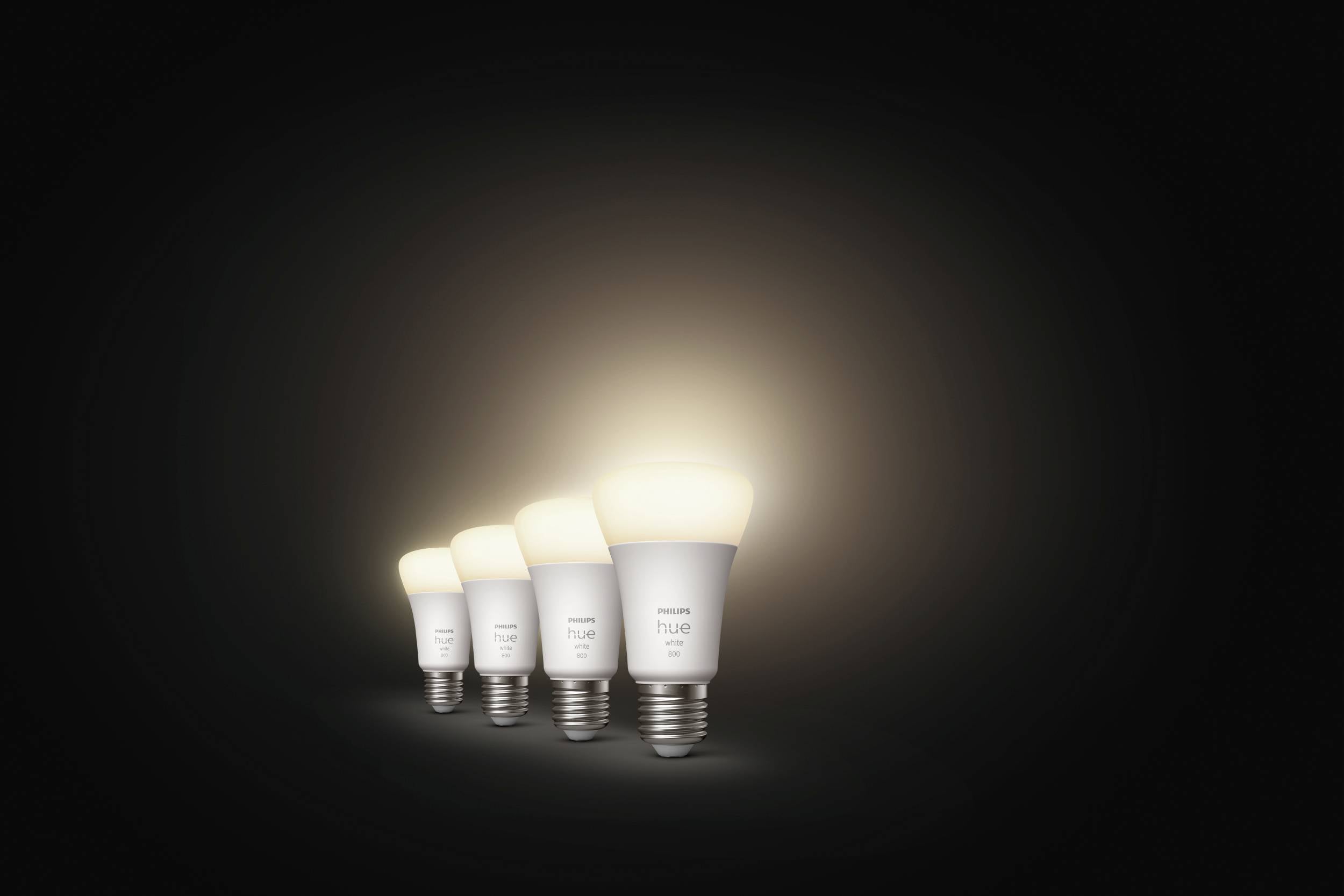 Quatre ampoules lumineuses alignées, dont la taille diminue progressivement de gauche à droite, sur un fond noir.