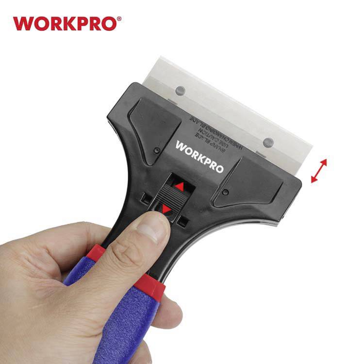 Une main tient un couteau utilitaire noir et bleu avec une lame interchangeable, la marque 'WORKPRO' est visible dessus.