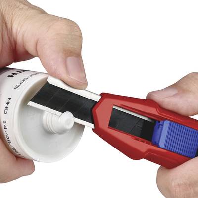 Une personne coupe l'extrémité d'un tube en plastique blanc à l'aide d'un cutter rouge.