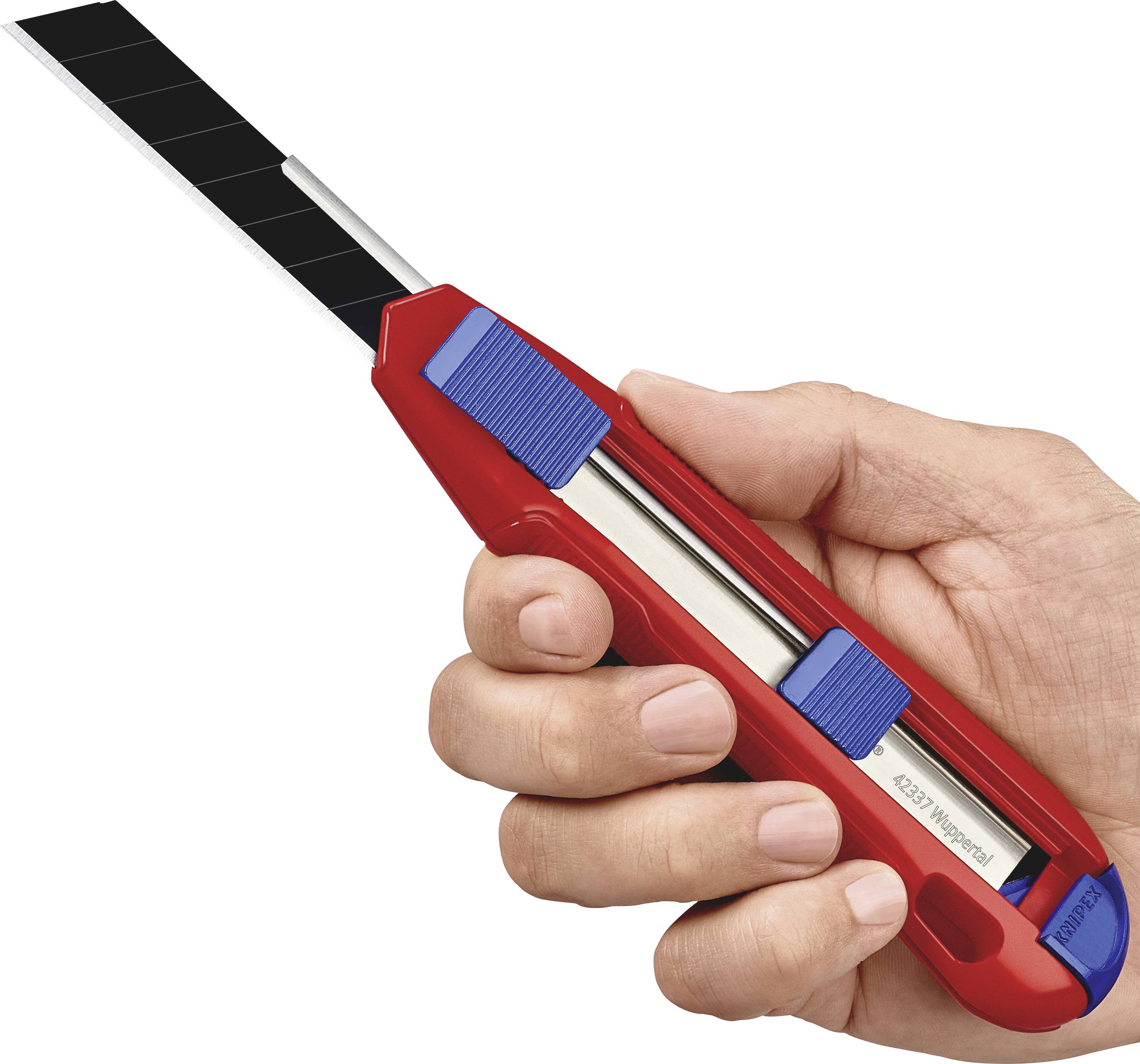 Une main tient un cutter rouge avec un manche bleu et une lame noire.