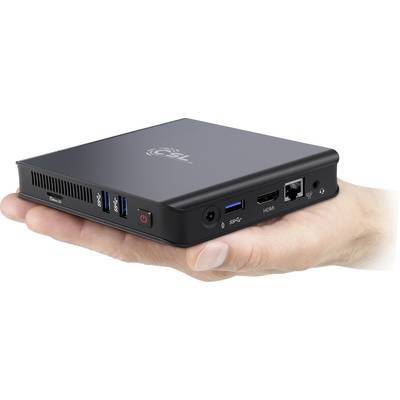 Une main tient un petit mini-PC noir avec plusieurs ports, notamment USB, HDMI et LAN.