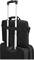 Un sac à dos noir pour ordinateur portable est enfilé sur la poignée d'une valise à roulettes noire.