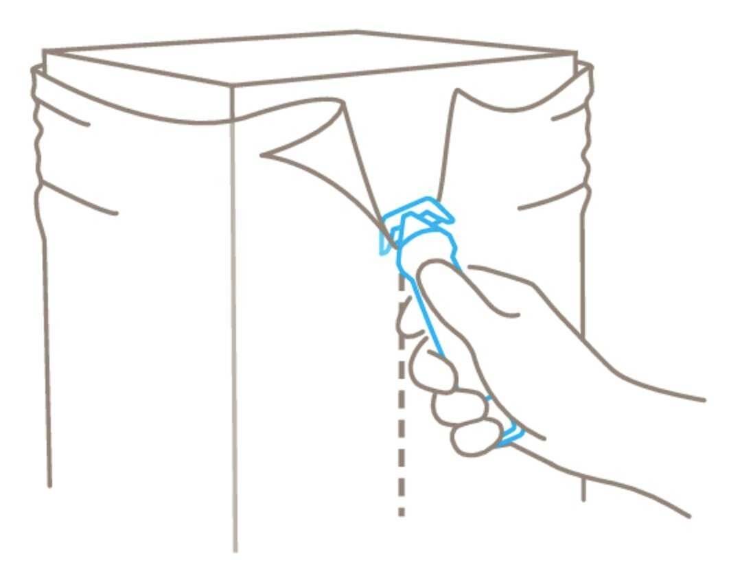 Une main ouvre un sachet à l'aide d'un coupe-zip.