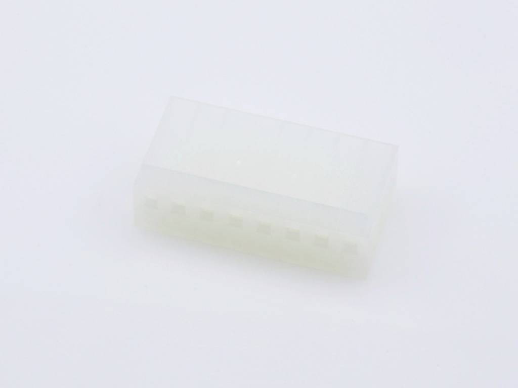 Un connecteur blanc en plastique avec plusieurs ouvertures de connexion, posé sur une surface blanche.