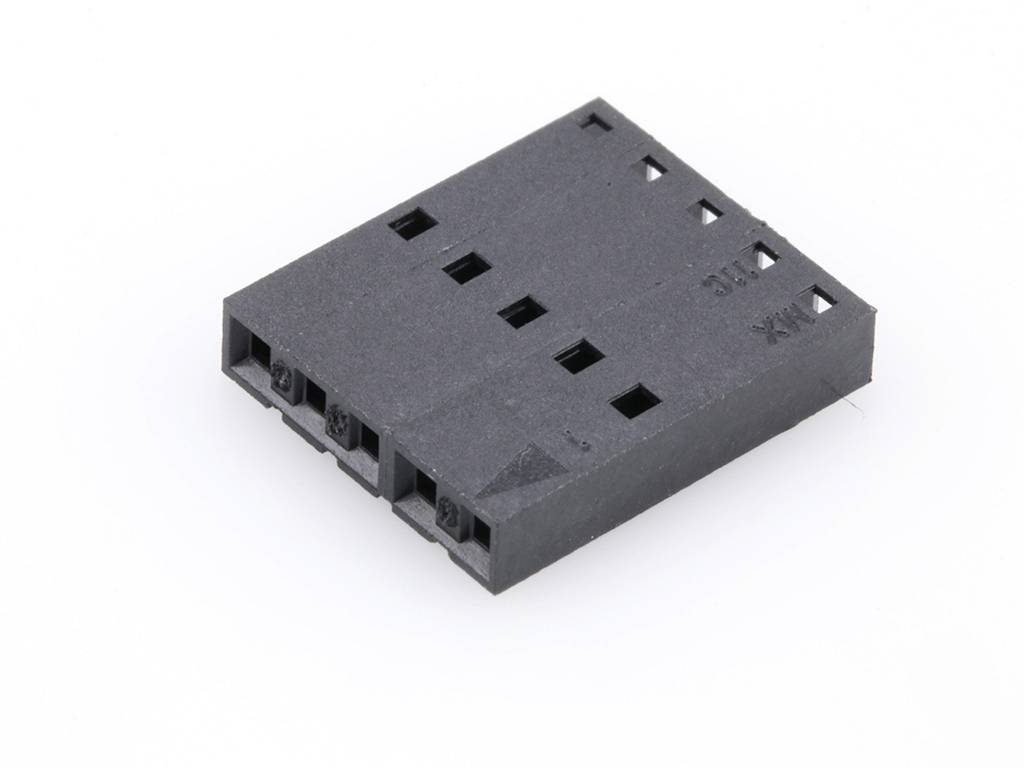 'Connecteur en plastique noir à plusieurs ouvertures, posé à plat sur un fond blanc.'