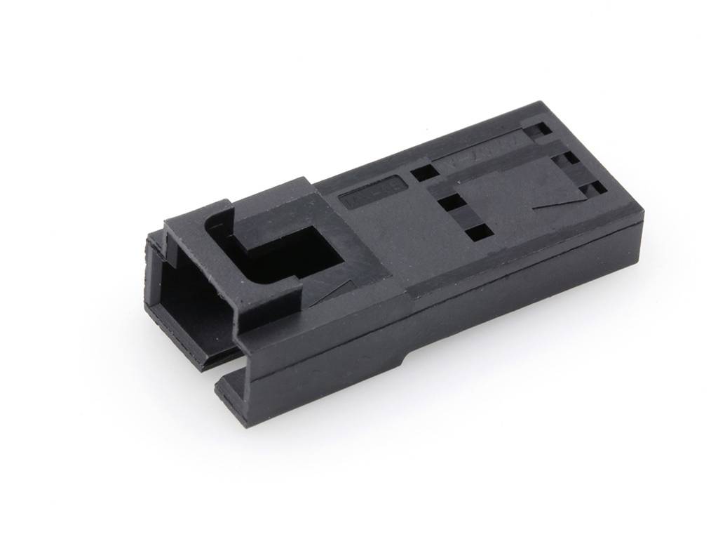 Un connecteur en plastique noir, de forme rectangulaire, avec une ouverture béante à une extrémité et plusieurs petites découpes rectangulaires.