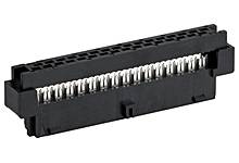Une prise électronique noire rectangulaire avec plusieurs broches métalliques, probablement un connecteur pour circuits imprimés.
