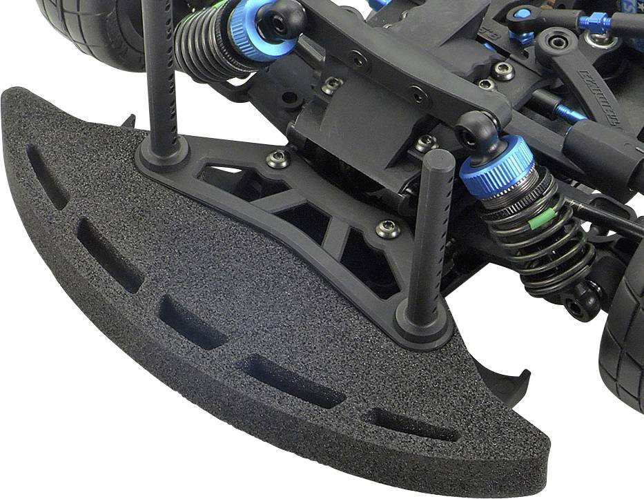 Gros plan sur une voiture télécommandée montrant le système de suspension de roue avant avec des amortisseurs bleus et un pare-chocs en mousse noire.