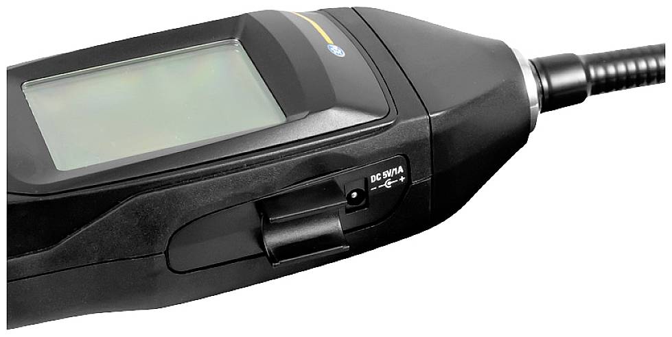 Appareil portable doté d'un écran et d'une connexion filaire, probablement un instrument de mesure ou un dispositif de communication.