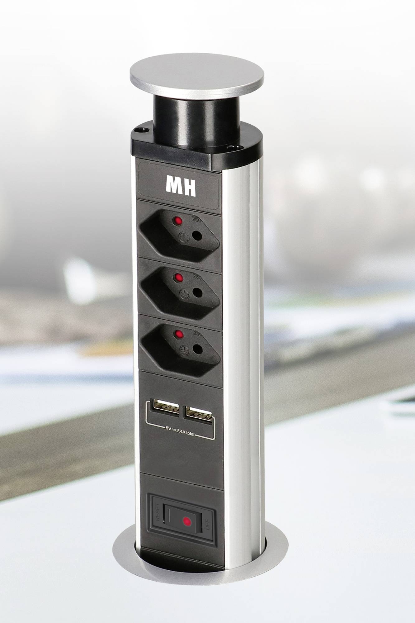 Une multiprise rétractable avec trois prises secteur et deux ports USB. Elle est intégrée dans un plateau de table.