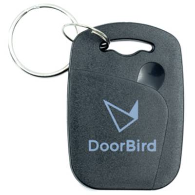 Porte-clés avec le logo DoorBird, boîtier noir, anneau porte-clés argenté, coins arrondis, poignée incisée en haut.