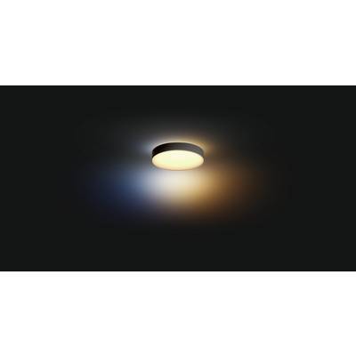 Un plafonnier rond diffuse une lumière chaude et jaunâtre dans une pièce sombre. Un léger dégradé de bleu et d'orange l'entoure.