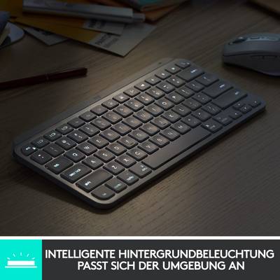 Clavier avec touches rétroéclairées sur un bureau. Texte en dessous : 'Rétroéclairage intelligent qui s'adapte à l'environnement'.