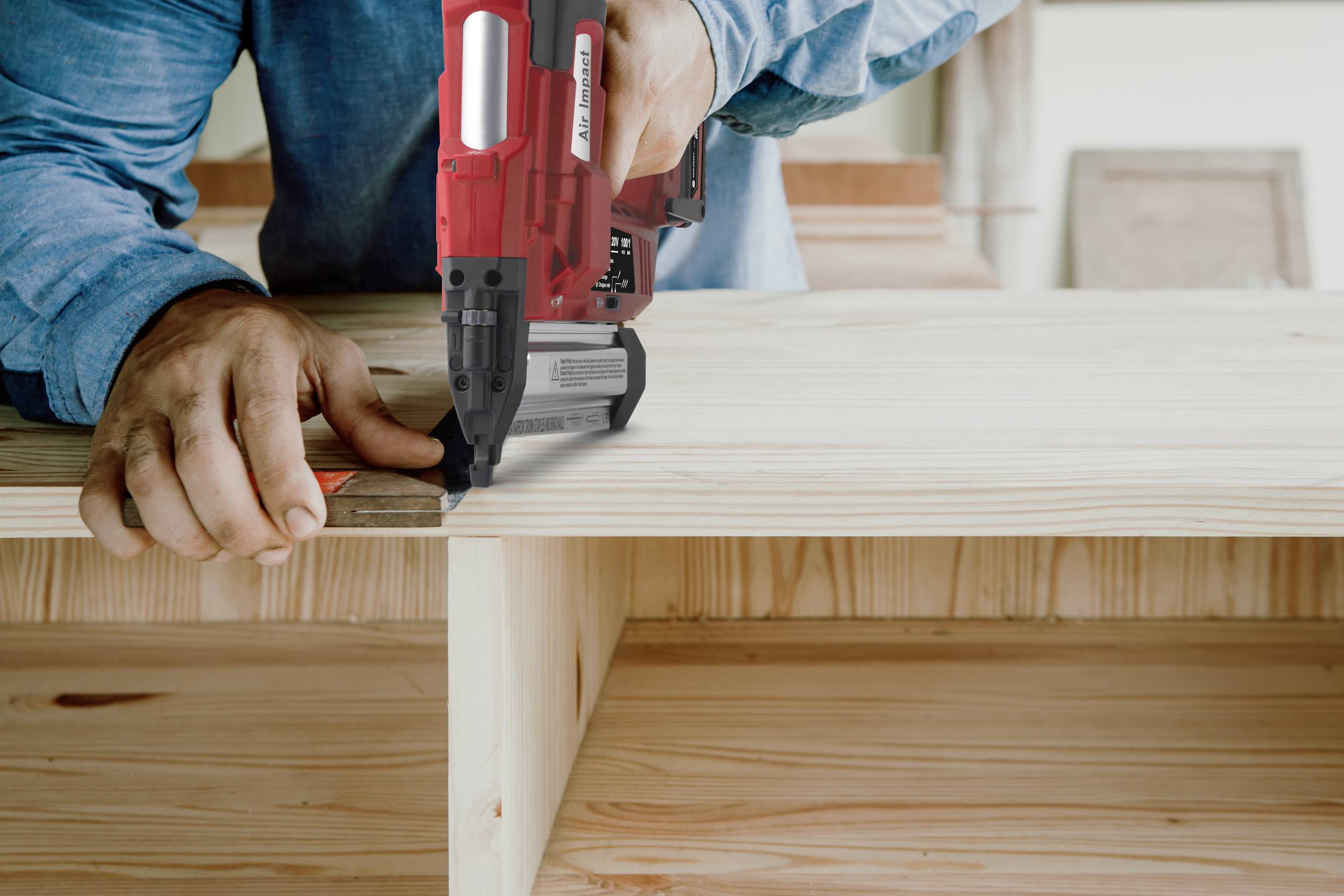 Une personne travaille le bois avec un outil électrique rouge. L'accent est mis sur la précision artisanale et l'activité de bricolage.