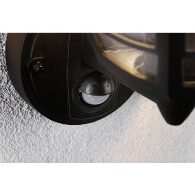 Détecteur de mouvement fixé sur un support de lampe murale indiquant le dispositif de détection de mouvements pour le contrôle automatique de l'éclairage.