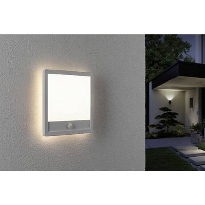Un applique murale rectangulaire avec détecteur de mouvement éclaire une façade de maison moderne au crépuscule.