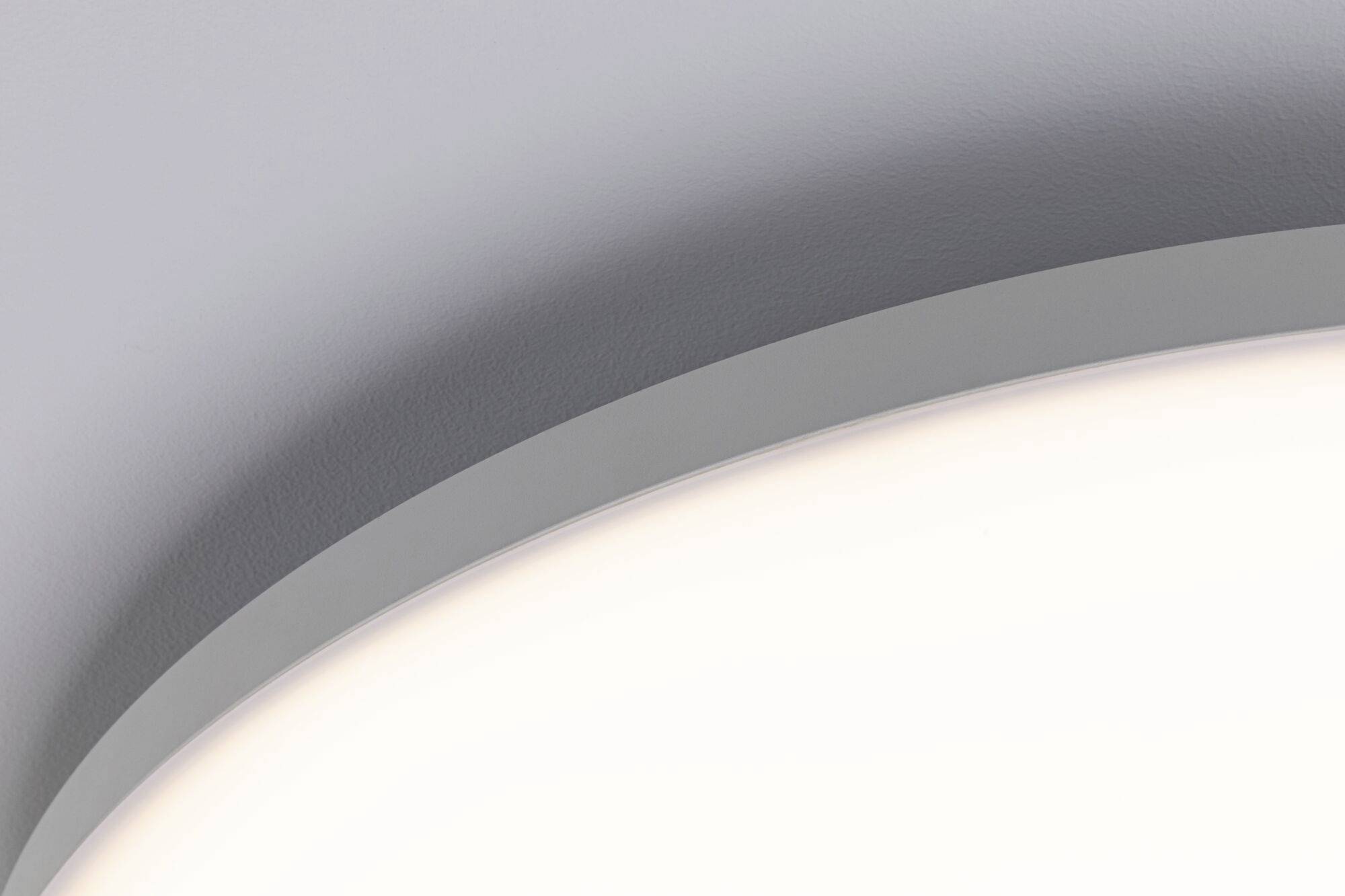 Gros plan sur un luminaire de plafond blanc moderne au design incurvé. Des surfaces lisses et une lumière douce illuminent la scène.