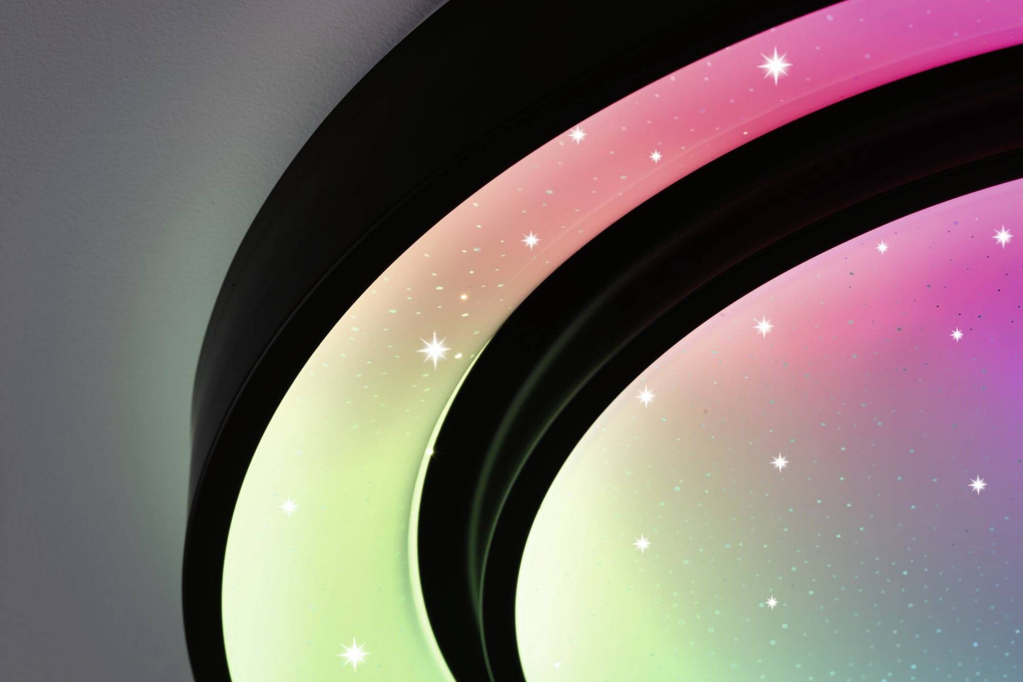 Panneau lumineux avec des dégradés de couleurs passant du vert au rose, parsemé de points lumineux blancs représentant des étoiles. Éclairage atmosphérique.