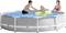 Un enfant joue dans une piscine gonflable avec un anneau de natation, tandis qu'un adolescent et une femme regardent.