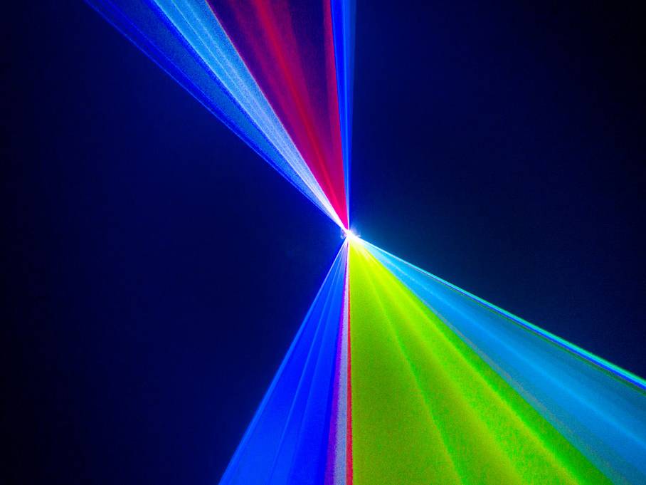 Des rayons lumineux abstraits en rouge, bleu et vert se rencontrent en un point sur un fond sombre, créant un motif luminescent.