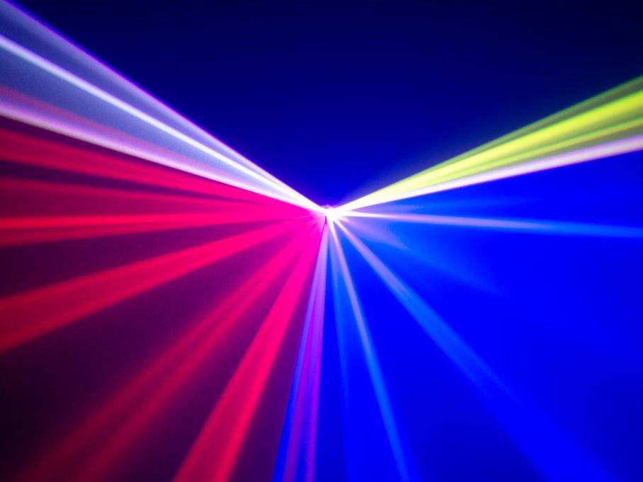 Des rayons lumineux colorés en rouge, bleu et vert s'irradient à partir d'un point central sur un fond sombre.